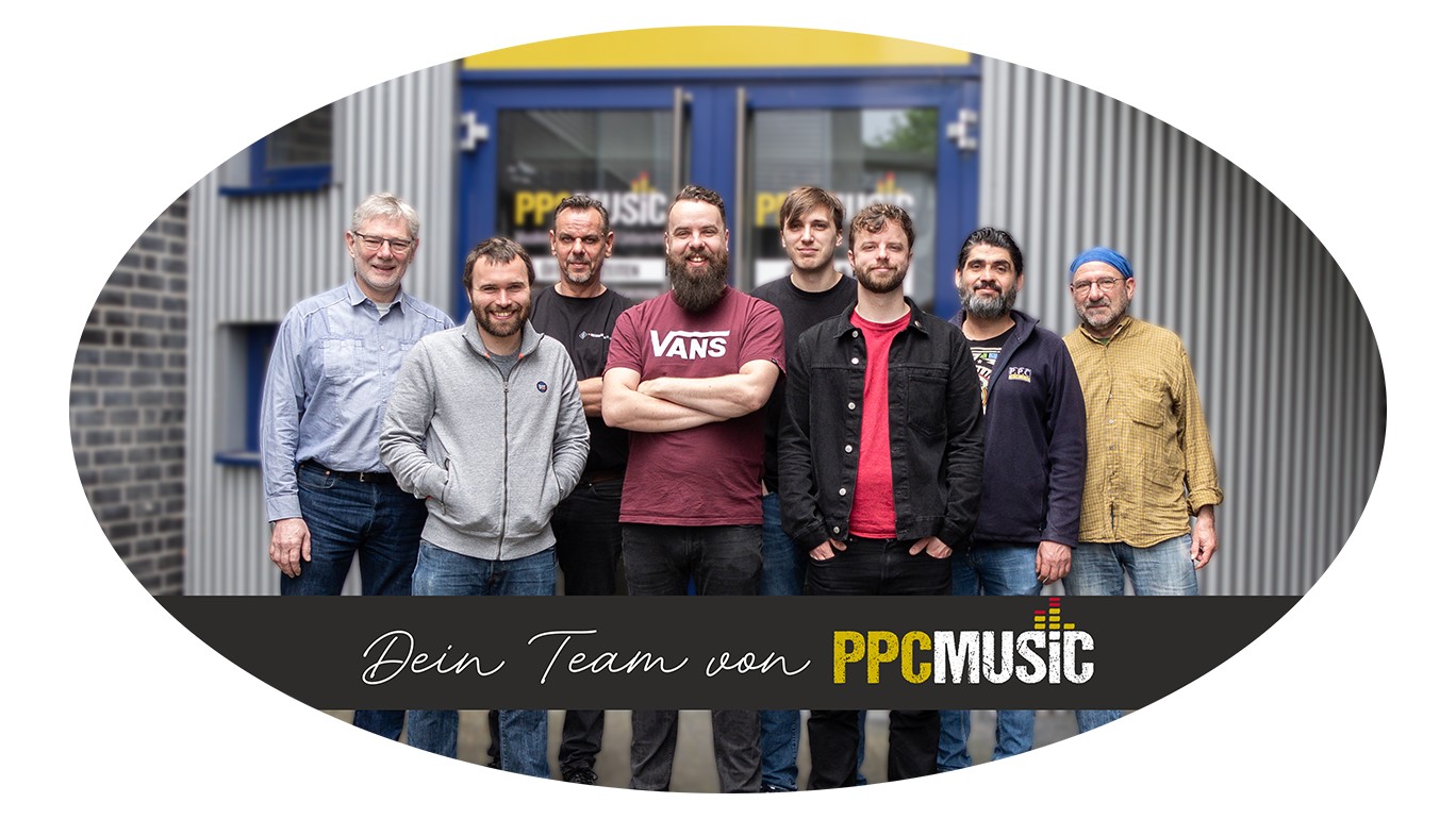 Das Team von PPC Music. Mehrere Personen vor einem Ladeneingang. Es handelt sich um das Team von PPCMusic.